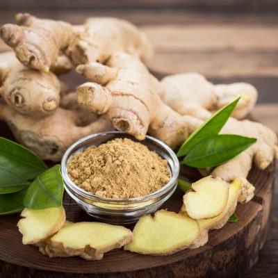 ginger-roots-with-powder-and-slices-on-wooden-board